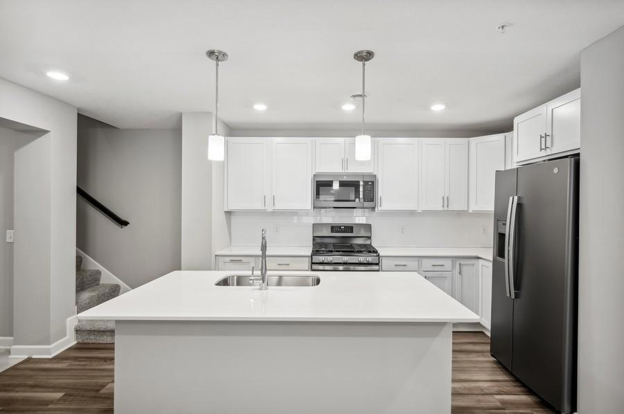 Thoughtfully-designed, modern and fresh describe this kitchen. Equipped with stainless appliances, quartz countertops, a kitchen island and plank-style flooring throughout, this kitchen adds distinction and character to the home.