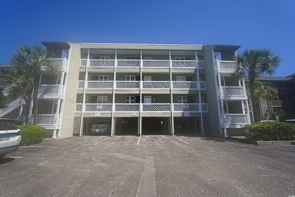 View of apartment building / complex featuring uncovered parking