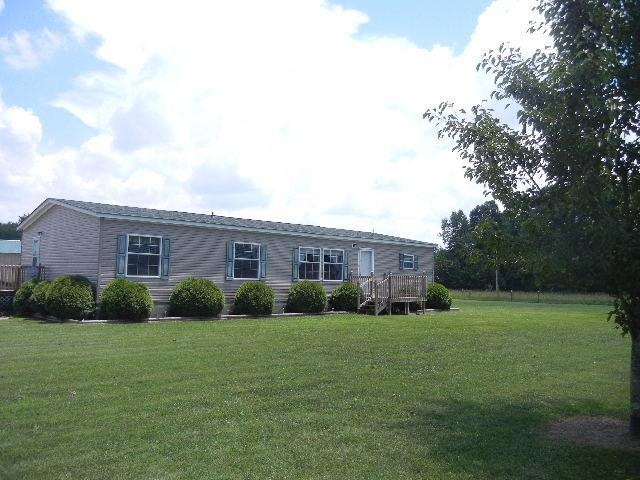 Nicely decorated and very well maintained manufactured home on a permanent foundation is surrounded by open fields. 
