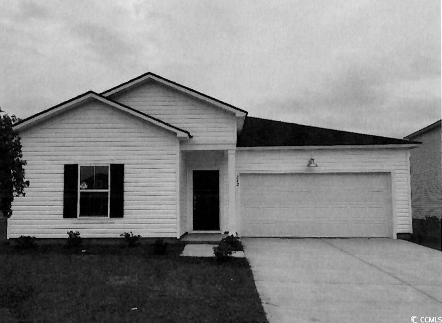View of front of house with concrete driveway and a garage