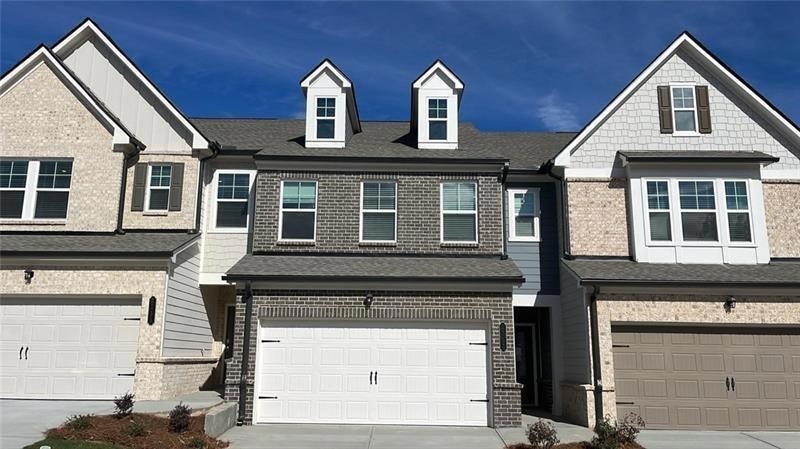 Multi unit property featuring brick siding, a gara