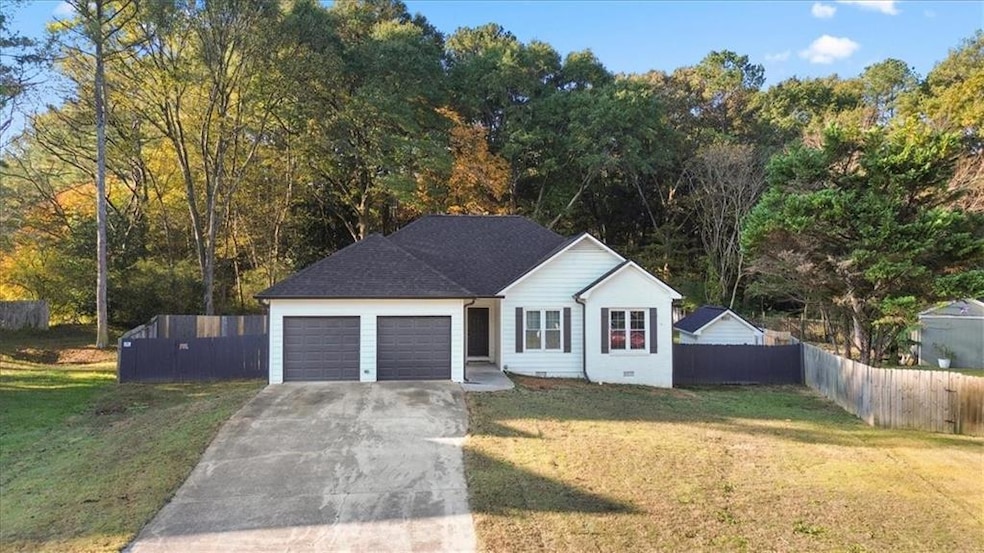 Single story home featuring driveway, roof with shingles, and a garage