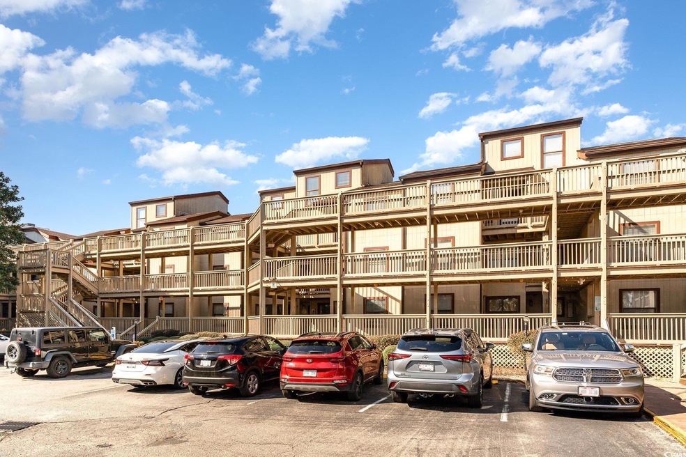 View of building exterior with uncovered parking