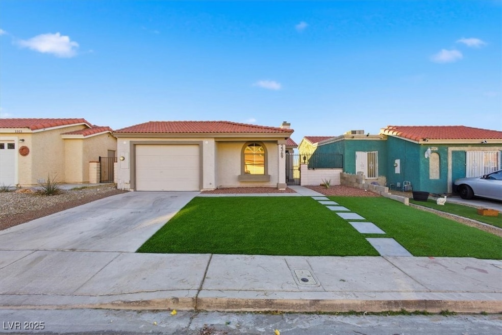 View of front of home featuring stucco siding, a gate, driveway, a chimney, and a tile roof