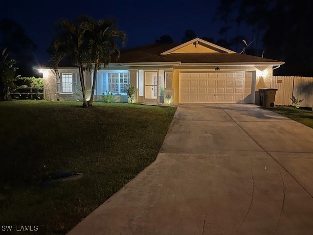 Single story home with a lawn, driveway, a garage,