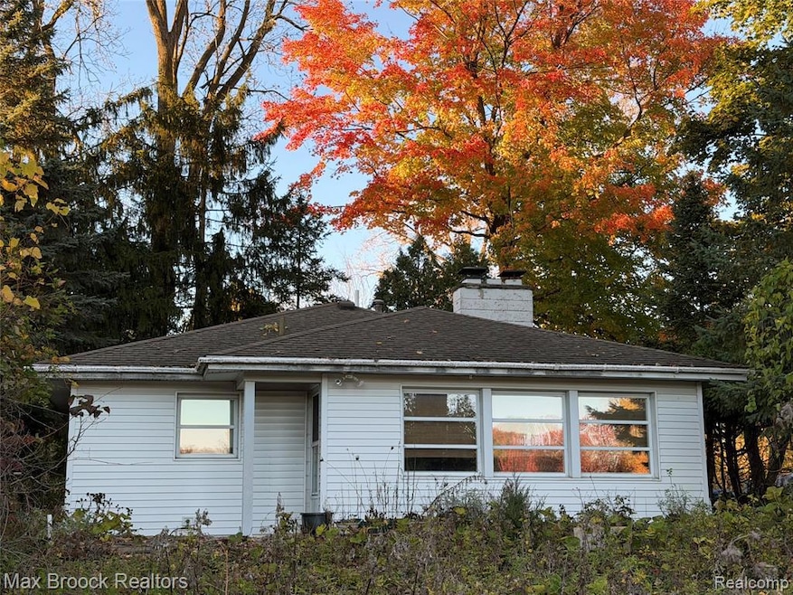 Rear view of house featuring a chimney and a shingled roof