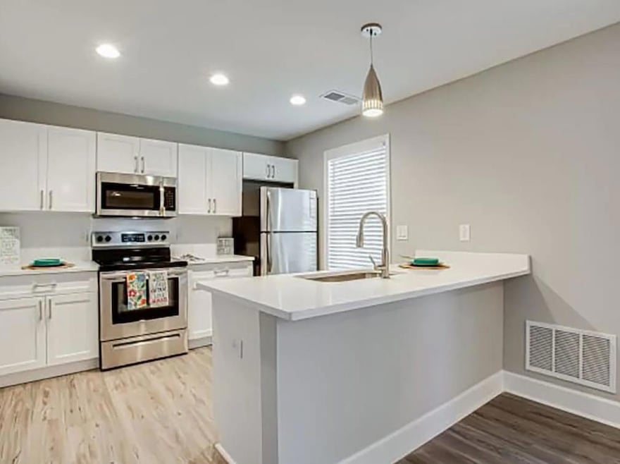 Kitchen with white cabinets, light wood-type floor