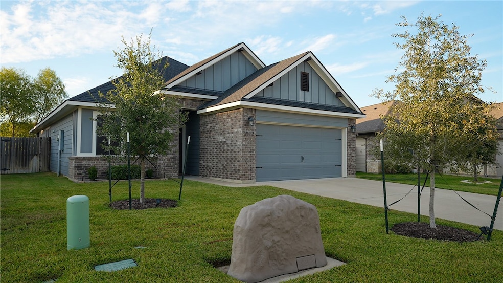 Craftsman-style house featuring board and batten siding, brick siding, concrete driveway, and roof with shingles