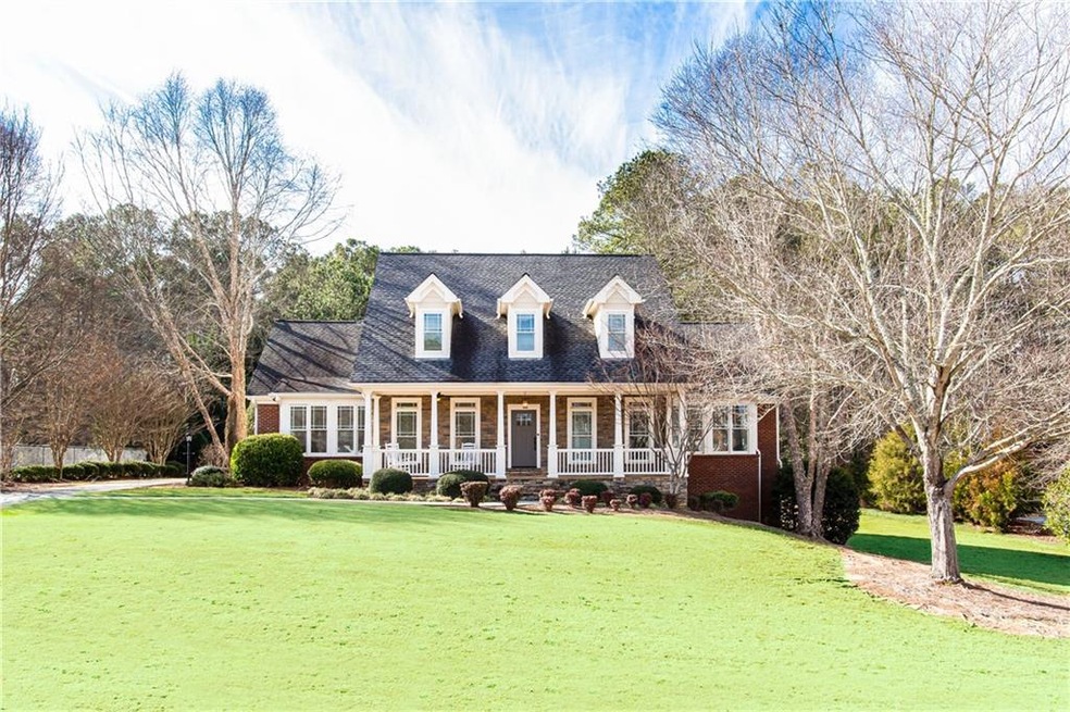 Cape cod house with a front lawn and a porch