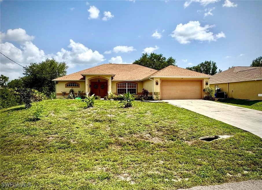 View of front of property featuring a garage, driv