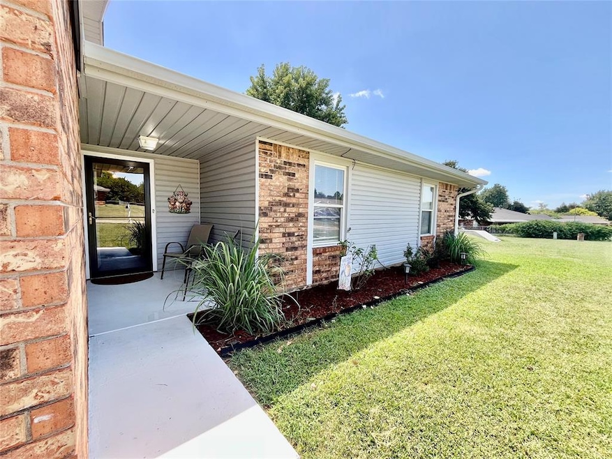 Entrance to property with brick siding and a lawn