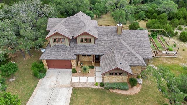 Stone paver walk to the entry! Salt finished wide driveway. Granite gravel driveway at the far left property line. Fenced area with raised garden beds on the right.