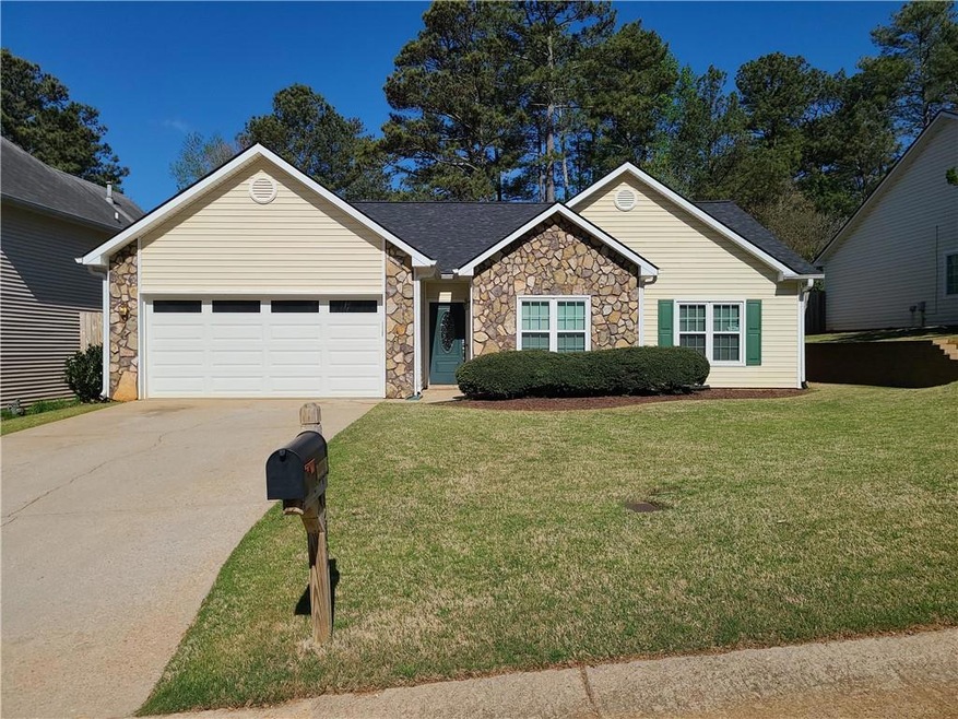 Ranch-style home with  front yard and garage
