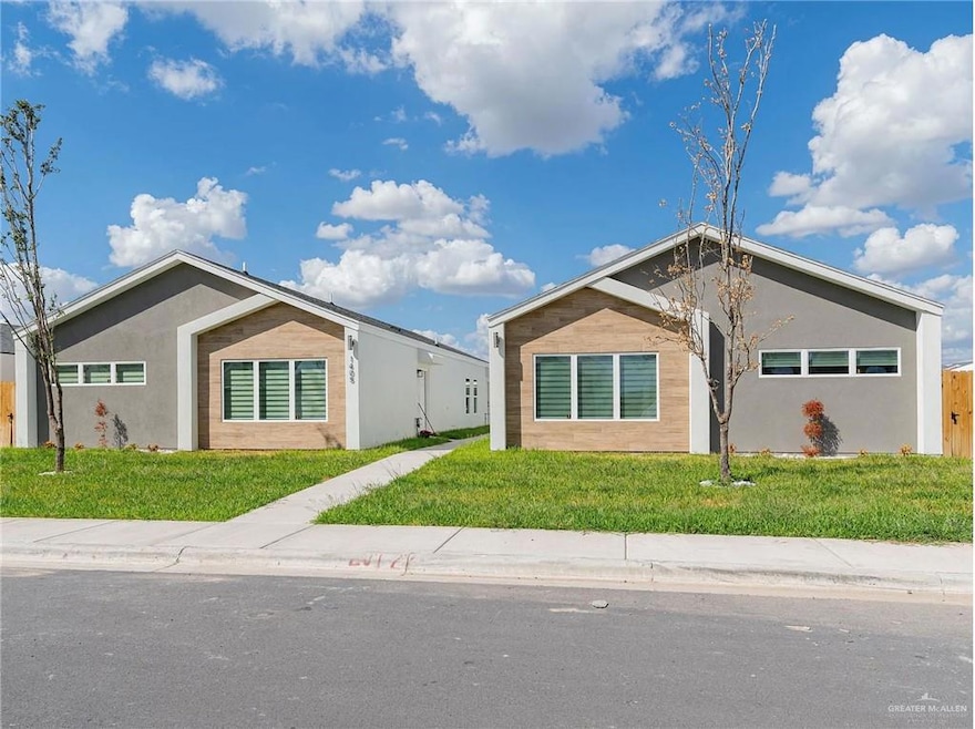 View of front of house with a front yard and stucco siding