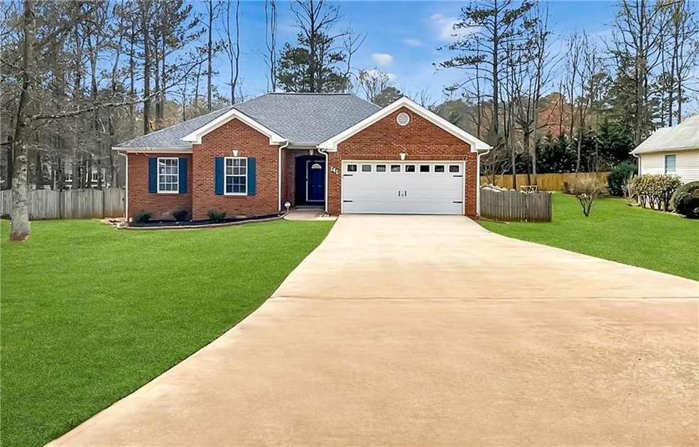 Single story home with a garage and a front lawn