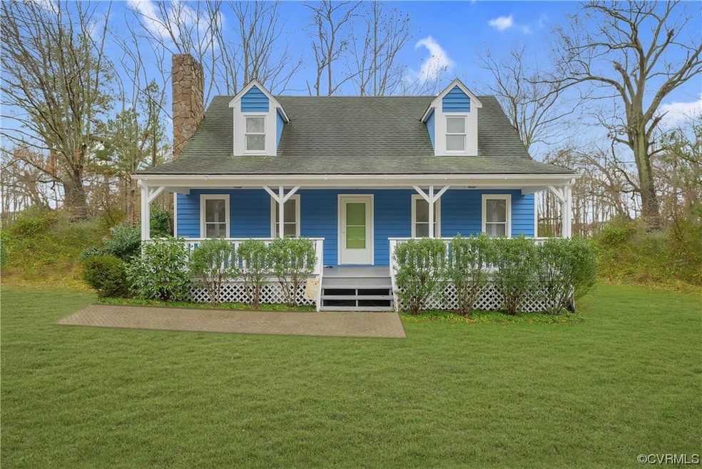 Cape cod home featuring a porch and a front yard