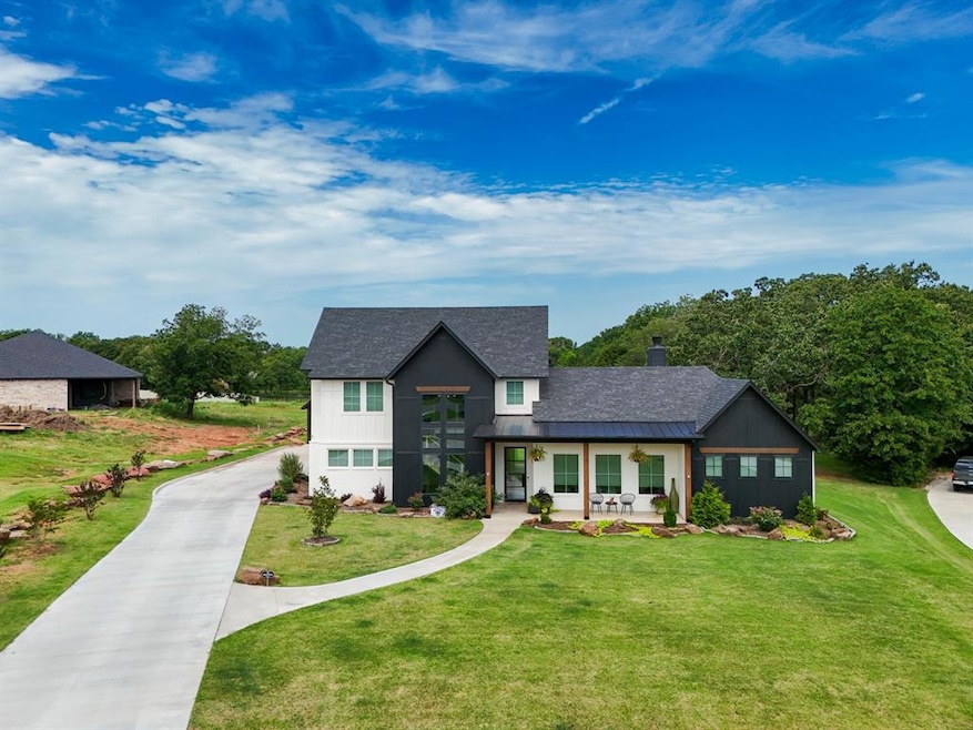 Modern farmhouse style home featuring covered porch, a front lawn, a chimney, a standing seam roof, and roof with shingles