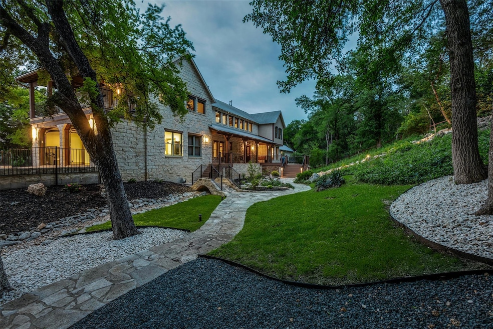 Rear view of house featuring stone siding and a y
