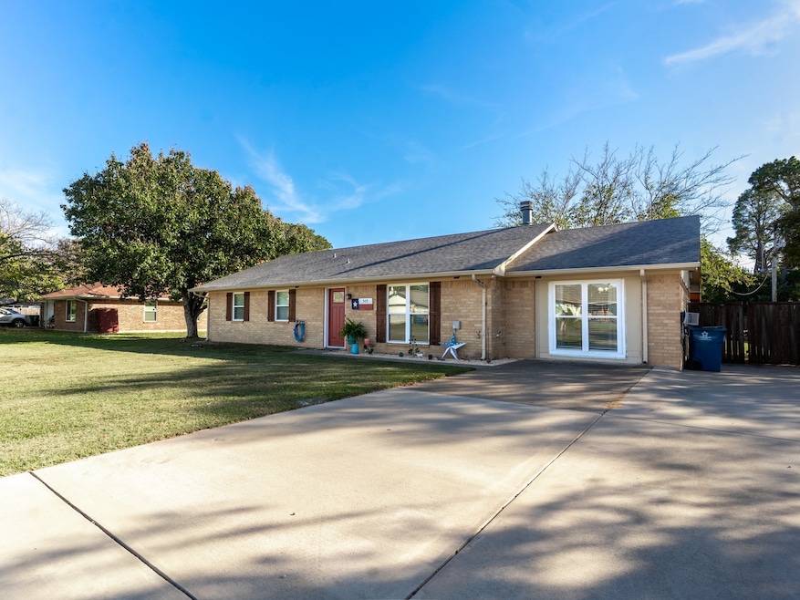 View of front facade featuring a front lawn, brick siding, a shingled roof, and concrete driveway
