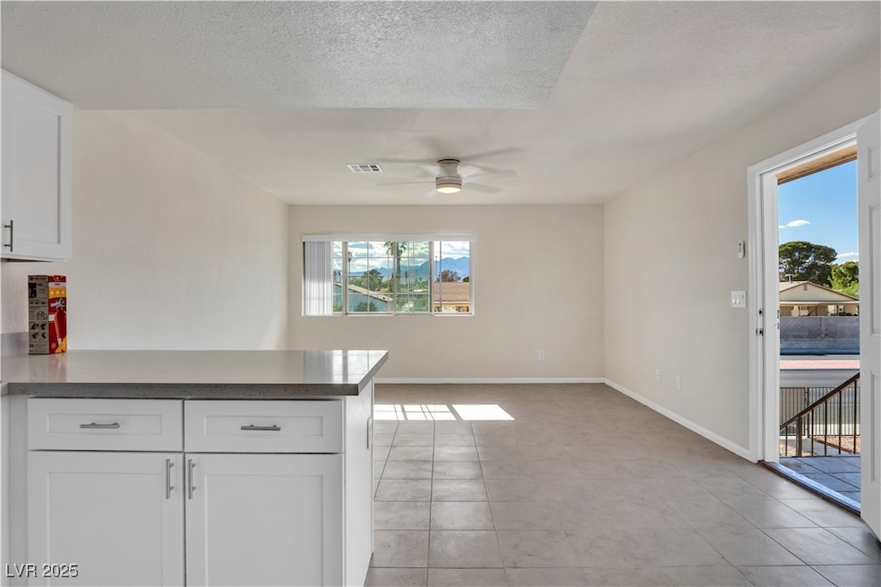 Kitchen with a ceiling fan, a peninsula, white cab
