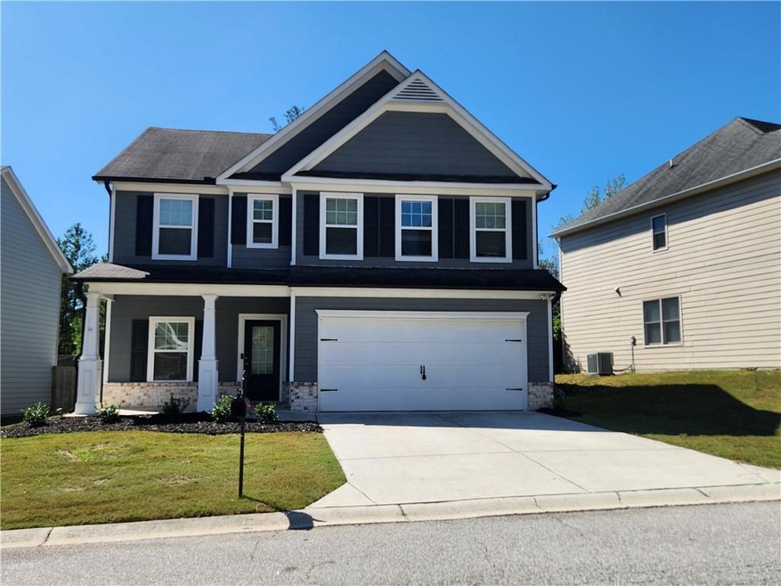 Craftsman-style house featuring a garage, central AC, and a front lawn