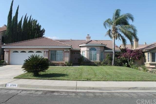 Manicured front lawn. Elegant bay window. Window a