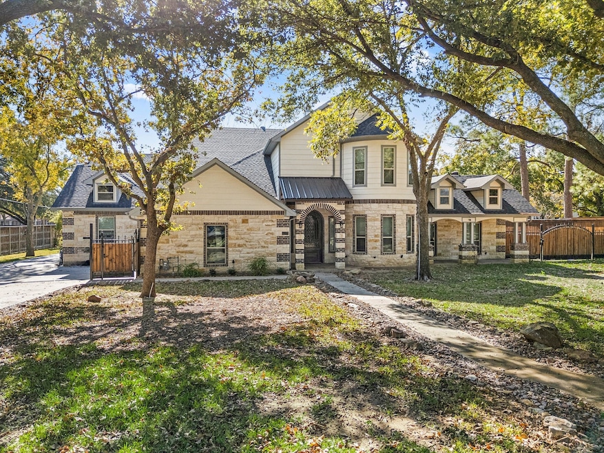 View of front of property with a gate, stone siding, and covered porch