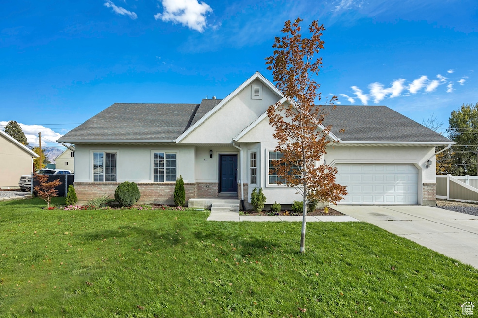View of front of property featuring brick siding, stucco siding, concrete driveway, a shingled roof, and an attached garage