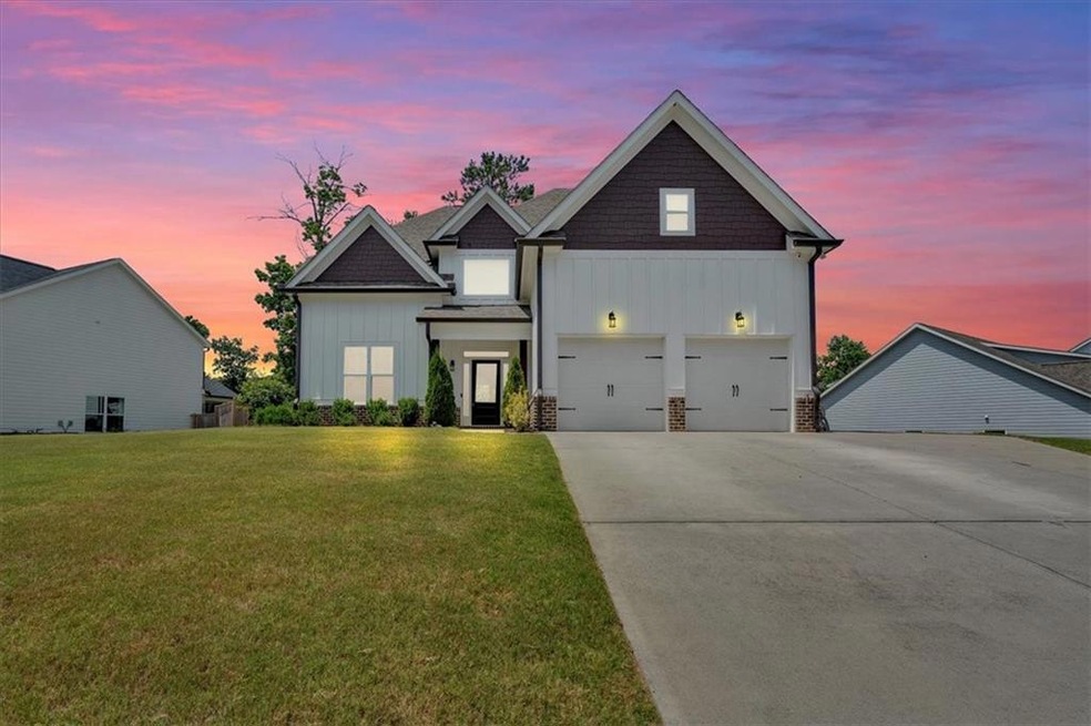 View of front of house featuring a garage and a ya