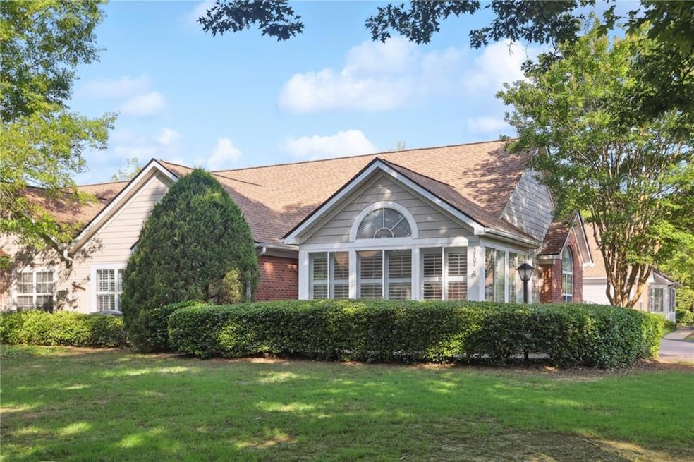 View of front of house with a front lawn, brick siding, and roof with shingles