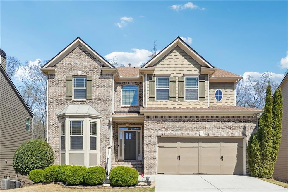 View of front of home featuring brick siding, a ga