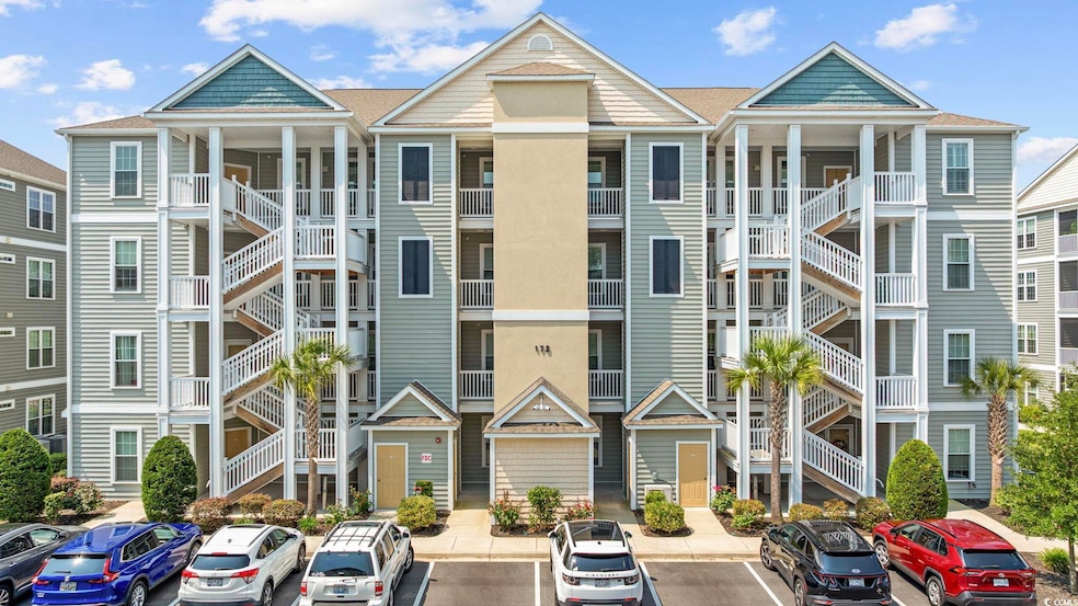 View of building exterior featuring uncovered parking and stairs