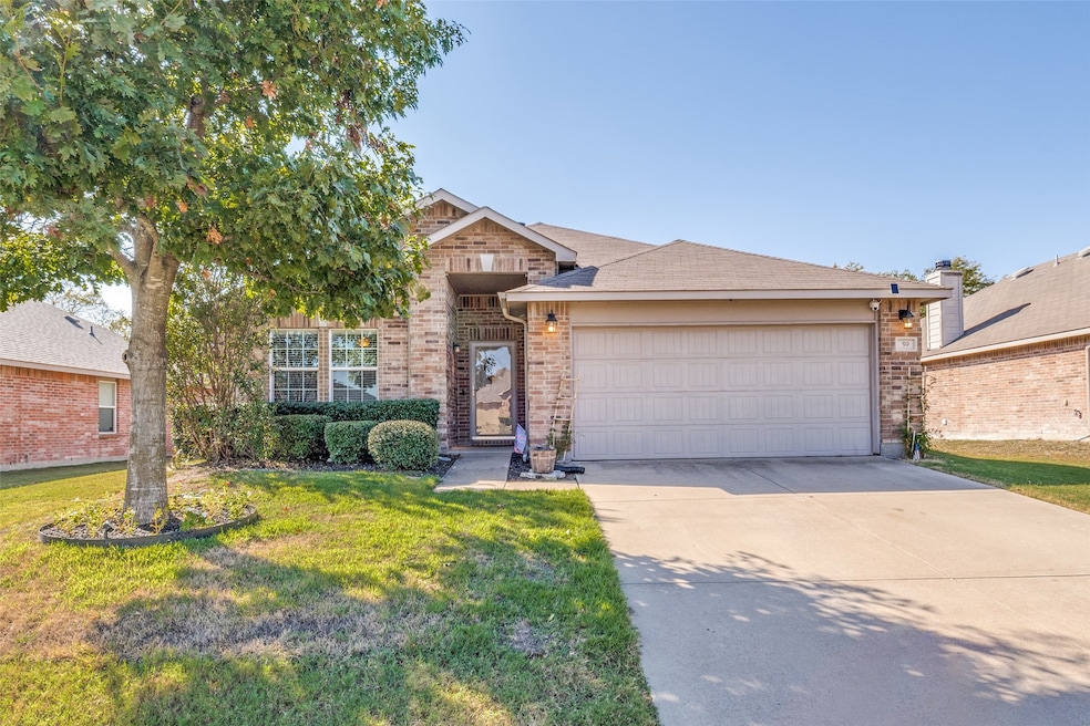 View of front of property with a front lawn, driveway, brick siding, and an attached garage
