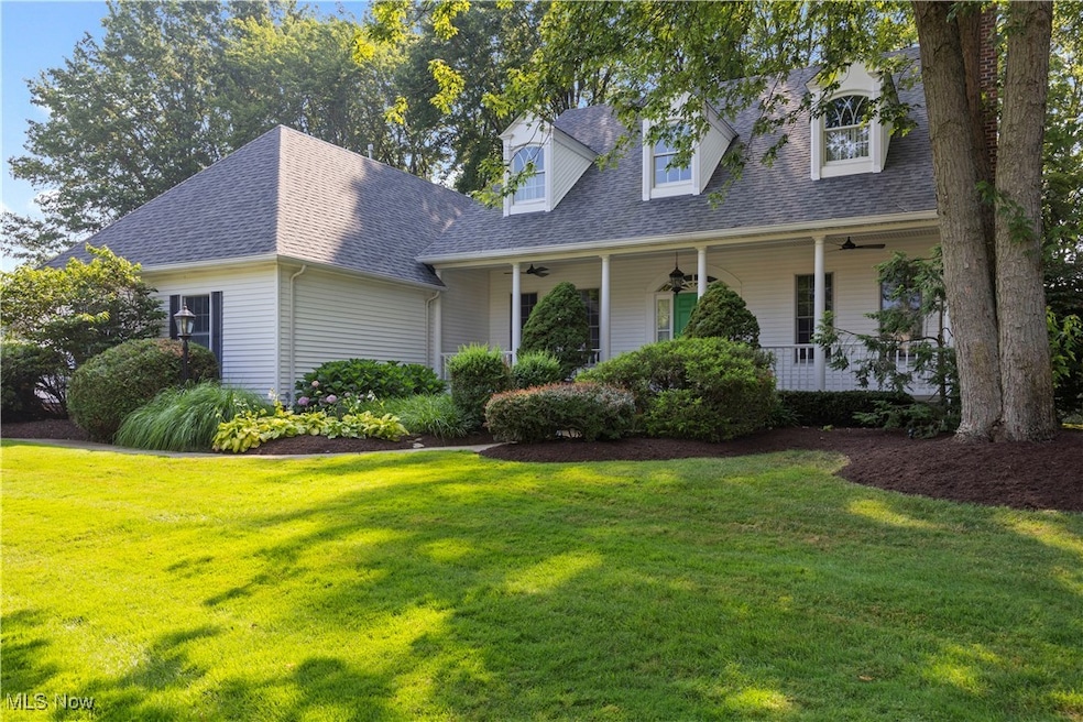 New england style home with a ceiling fan, a front yard, and a shingled roof