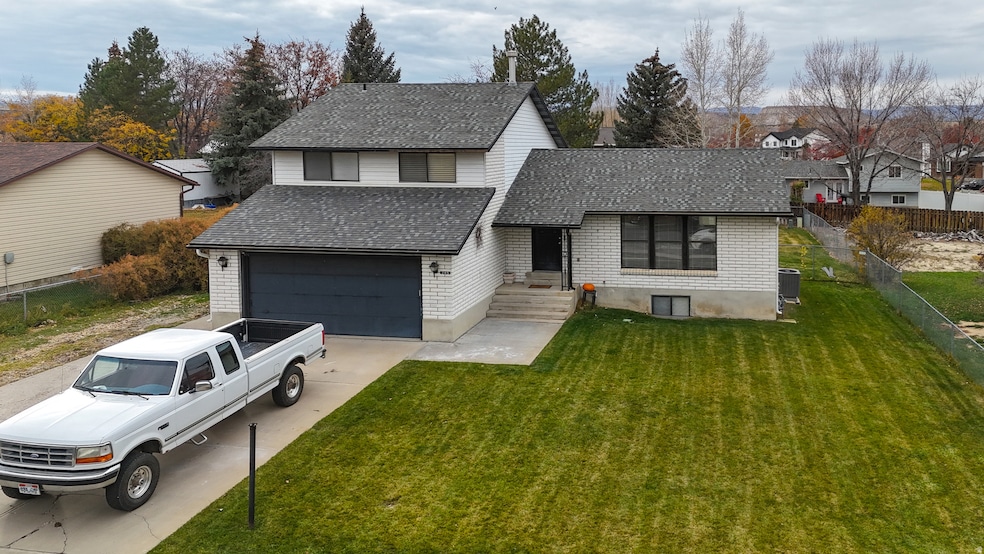 View of front facade featuring a shingled roof, driveway, a garage, a residential view, and brick siding