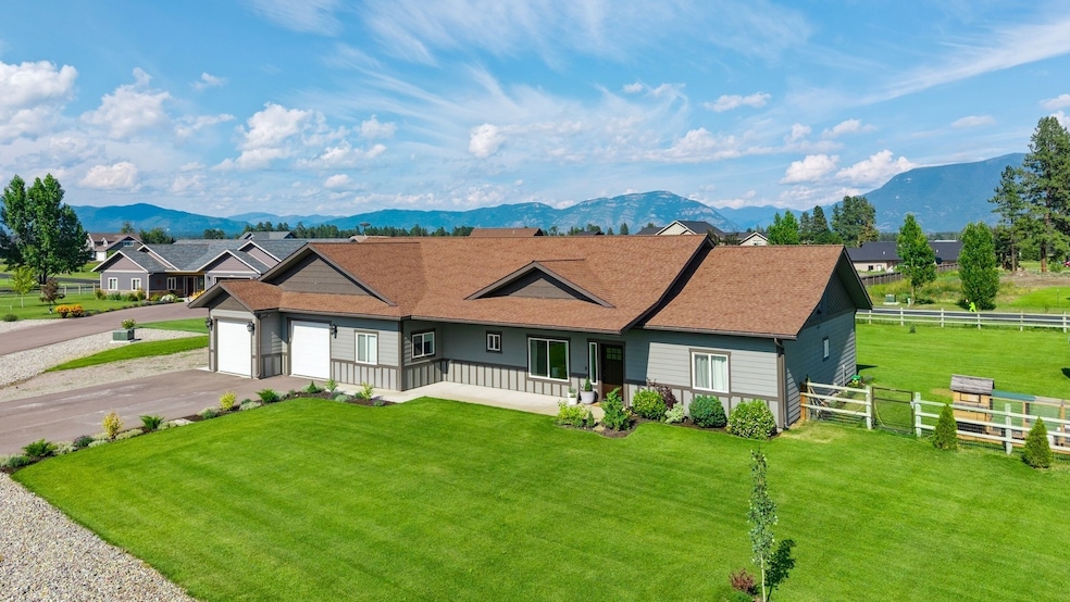 Ranch-style house featuring an attached garage, driveway, a shingled roof, a mountain view, and covered porch