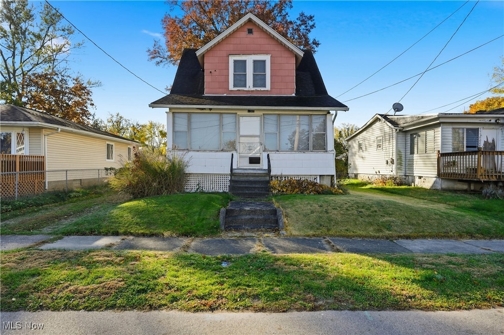View of front of house with entry steps and a front lawn