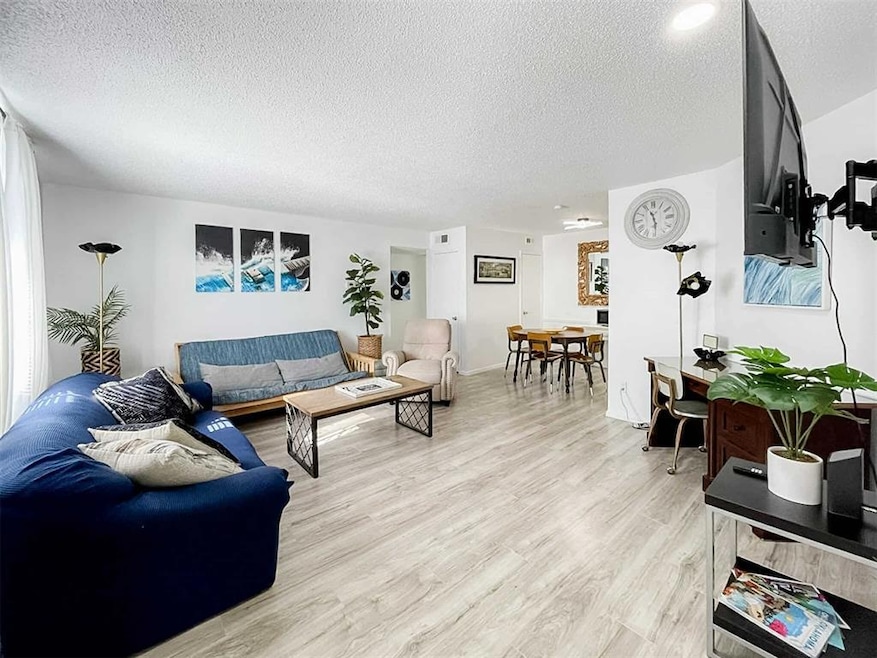 Living area featuring a textured ceiling and light wood finished floors