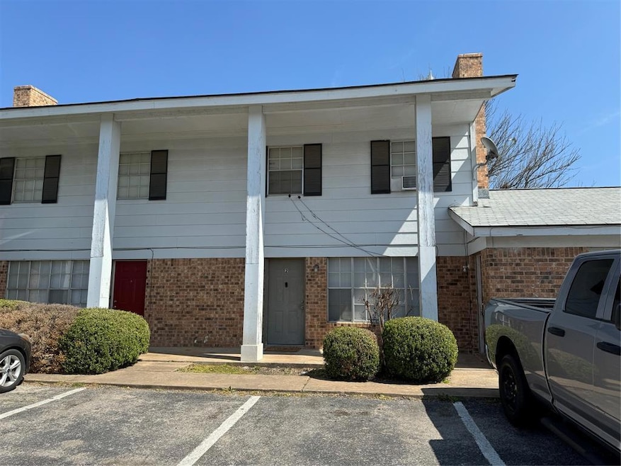 View of property featuring uncovered parking