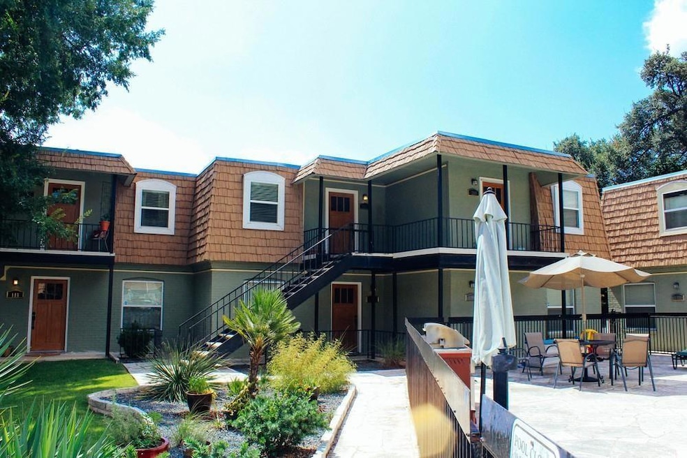 Rear view of property featuring mansard roof, sta