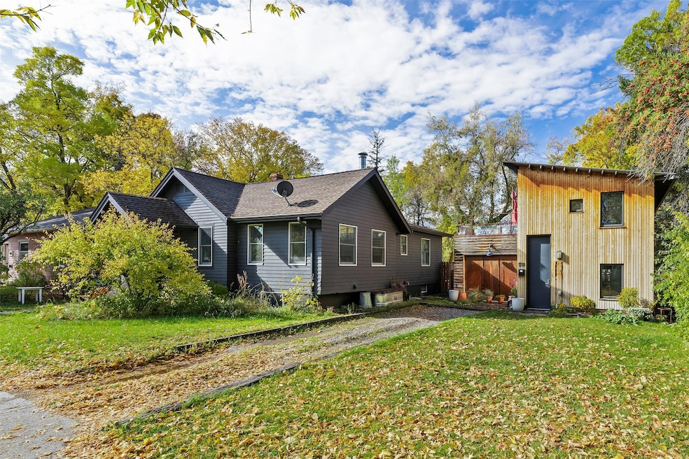 View of front of house with a front yard and a storage shed
