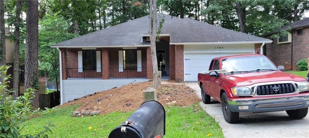 Ranch-style home featuring a porch and a garage