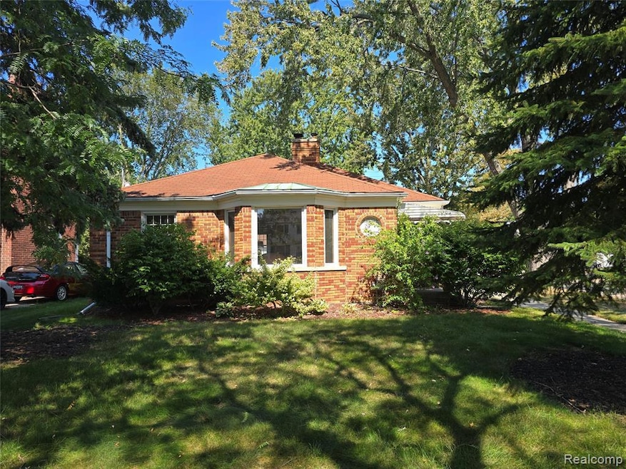 View of front of house featuring brick siding, a front yard, and a chimney