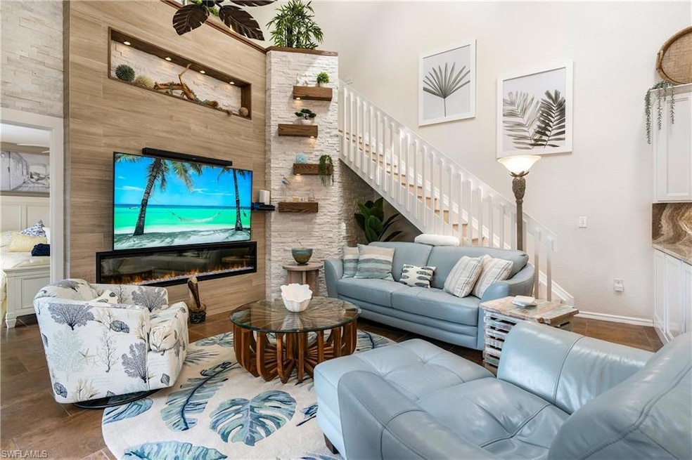Living room with a glass covered fireplace and stairway