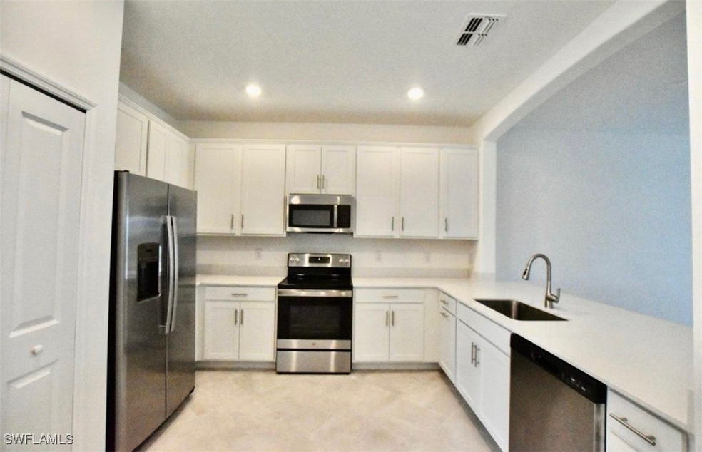 Kitchen featuring visible vents, a sink, white cab