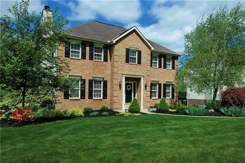 Custom brick front built by Pitell builders ~ beautiful level entry enhanced by professional landscaping creates stunning curb apppeal