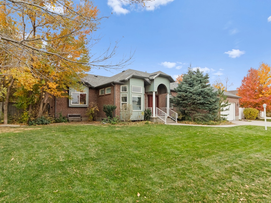 View of front facade featuring brick siding, a front lawn, and a garage