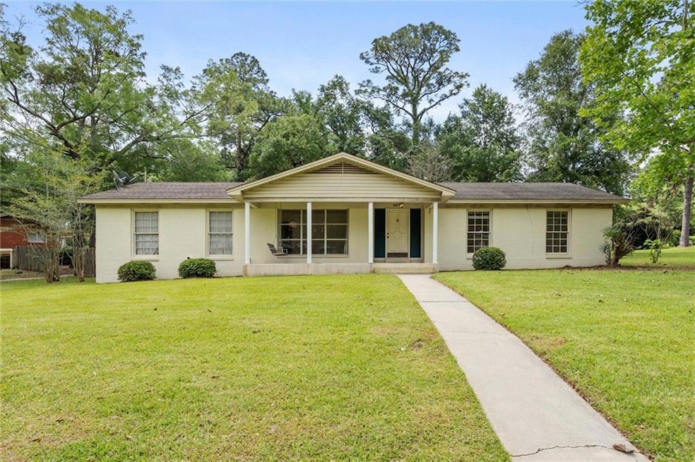 Ranch-style home with a front yard and a porch.