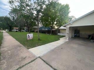 View of green lawn featuring concrete driveway