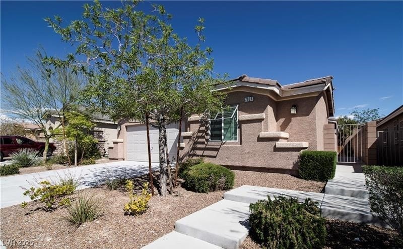 View of front facade with driveway, stucco siding,